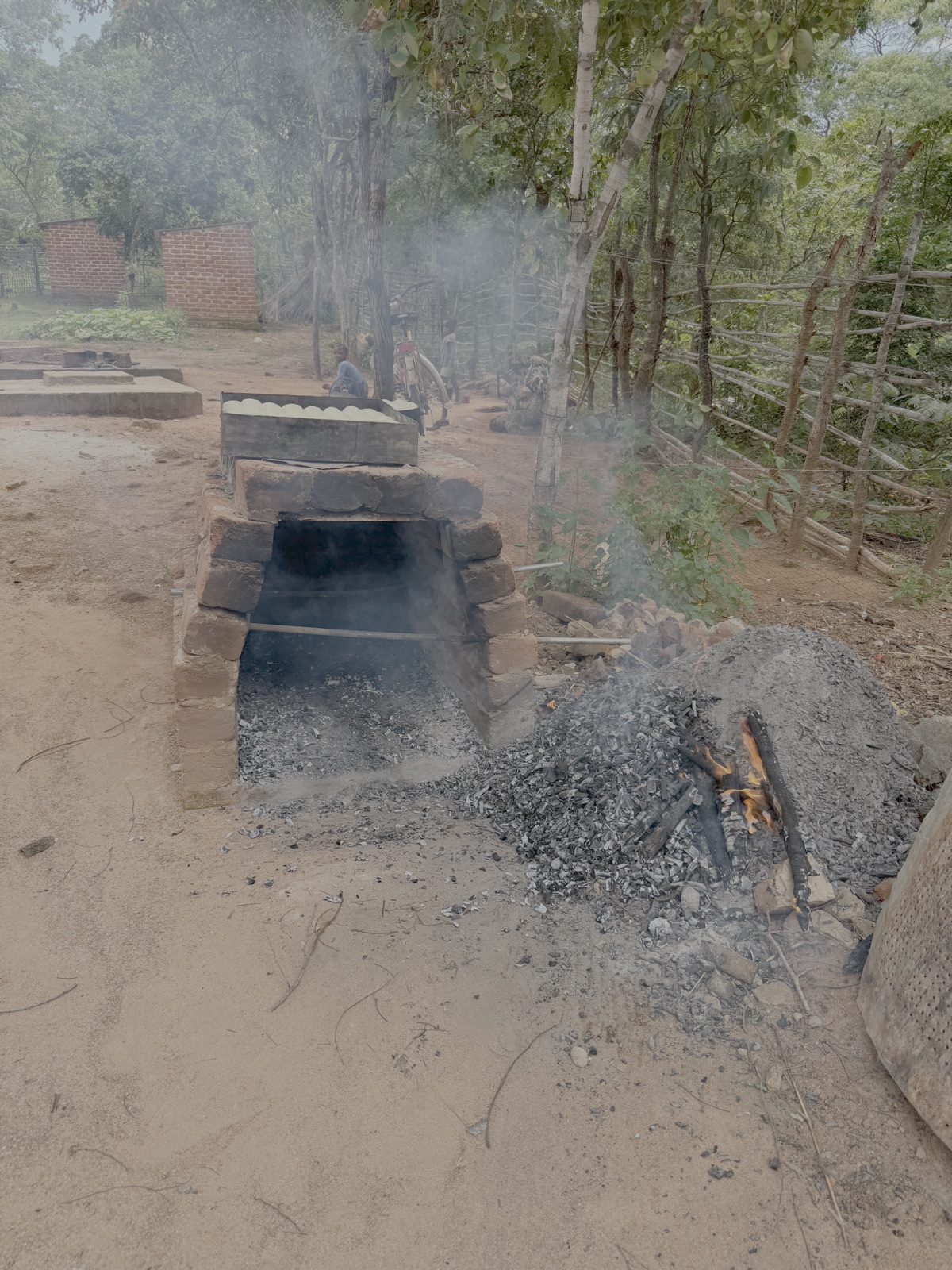 Vervolgens worden de brandende takken eruit gehaald. De as en houtskool worden later gebruikt voor de compost.